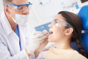 dentista-examinando-os-dentes-de-um-paciente_1098-1540